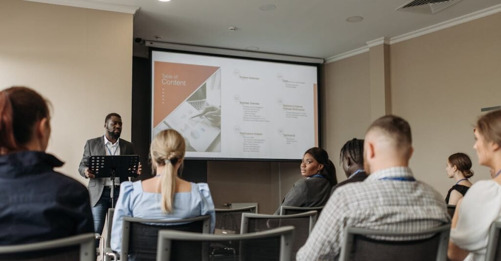 Audience attentively listening to a business presentation in a conference room setting.